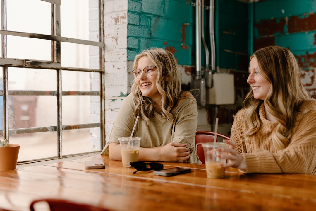 A small group of women gathered in a warm community space, sharing an unhurried moment together