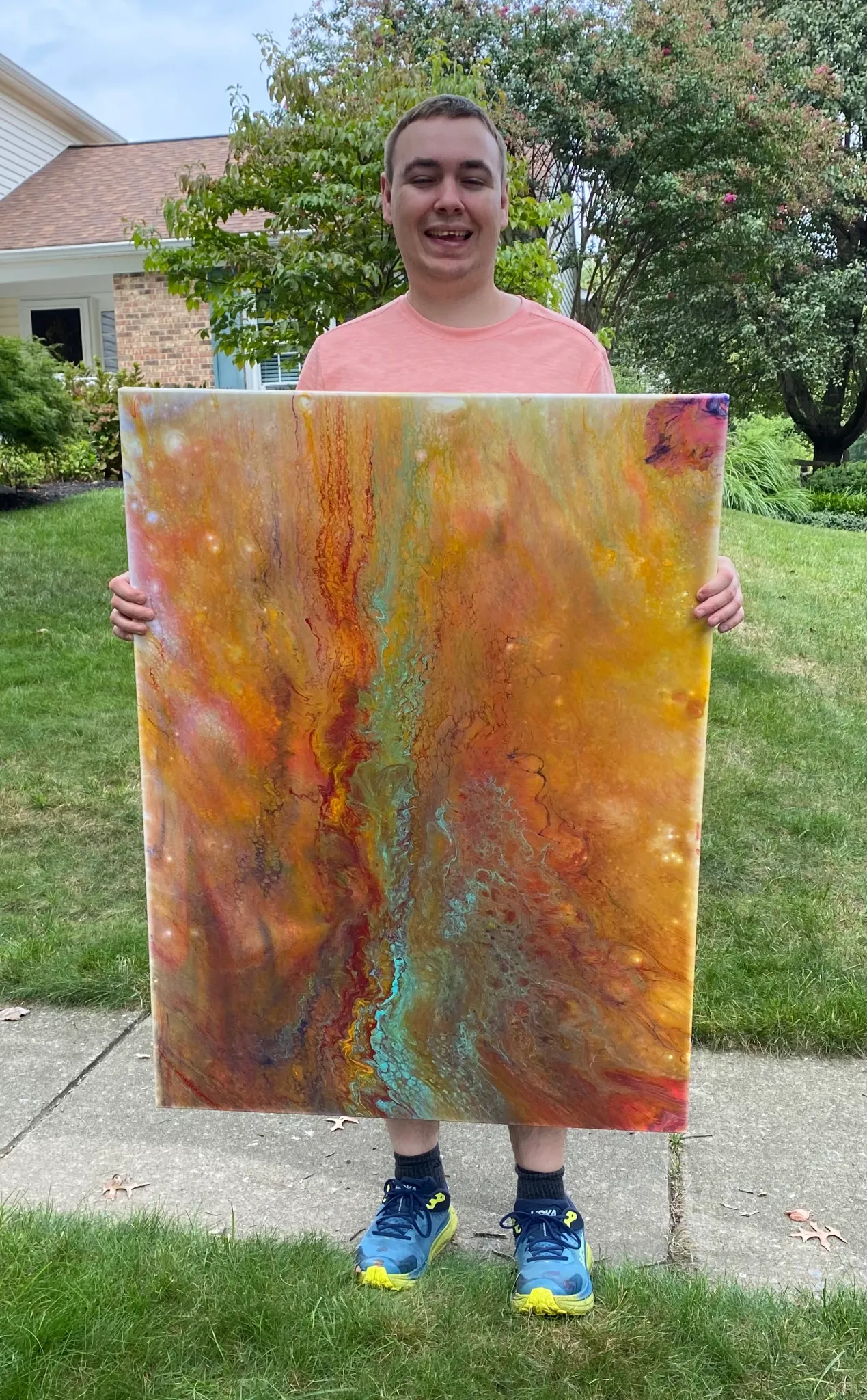 Justin Valenti holding one of his paintings